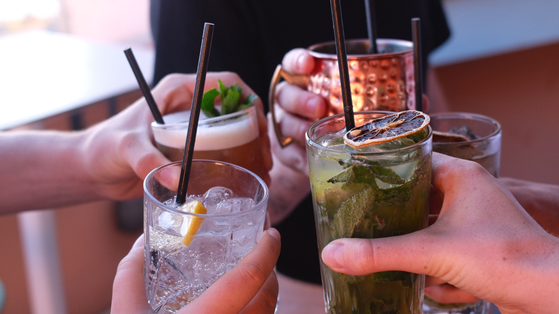 Personnes trinquent avec cocktails variés.