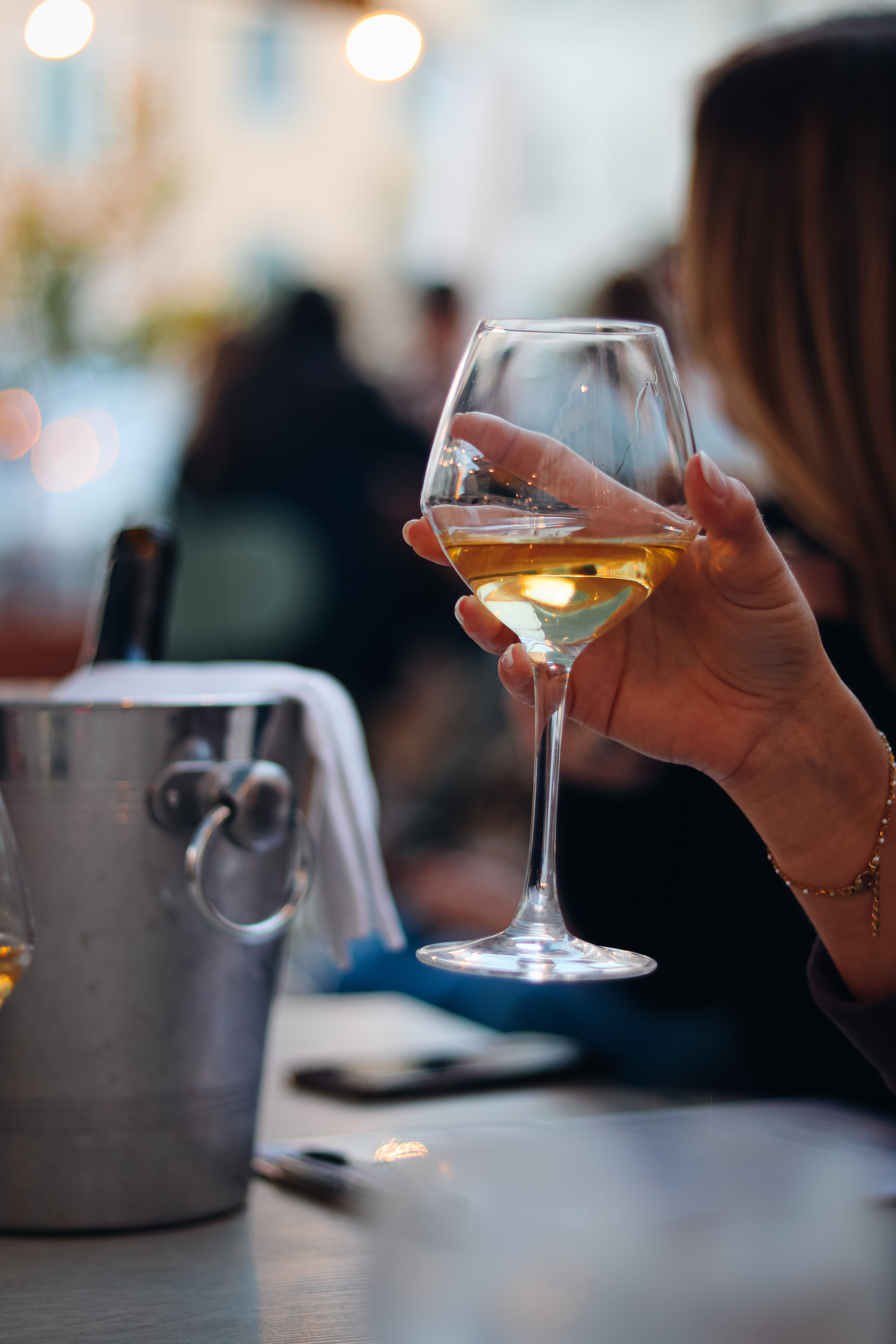Verre de vin blanc en main.
