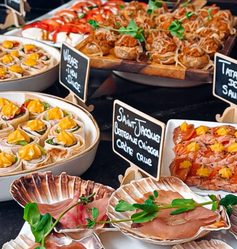 Buffet varié avec plats de saumon, wraps, coquilles.
