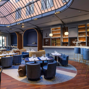 Restaurant moderne avec bar et tables élégamment dressées.