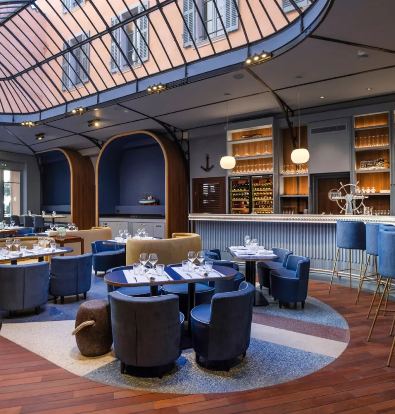 Restaurant moderne avec bar et tables élégamment dressées.