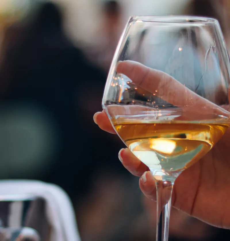 Verre de vin blanc dans une main.