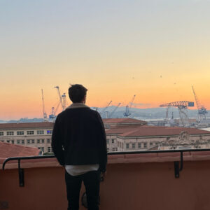 Homme regardant un coucher de soleil sur le port.